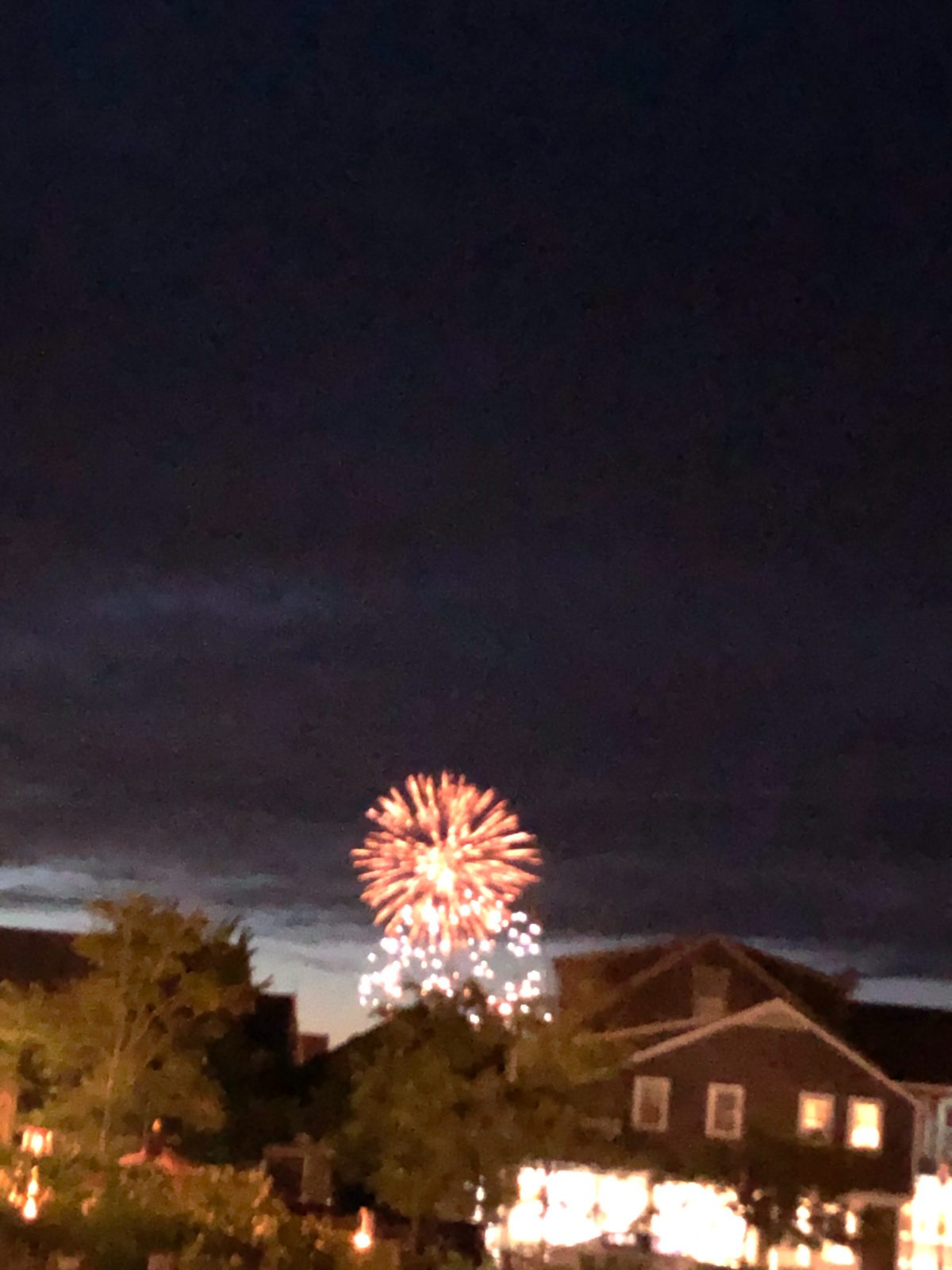 Fireworks bursting over Nantucket rooftops on the Fourth of July